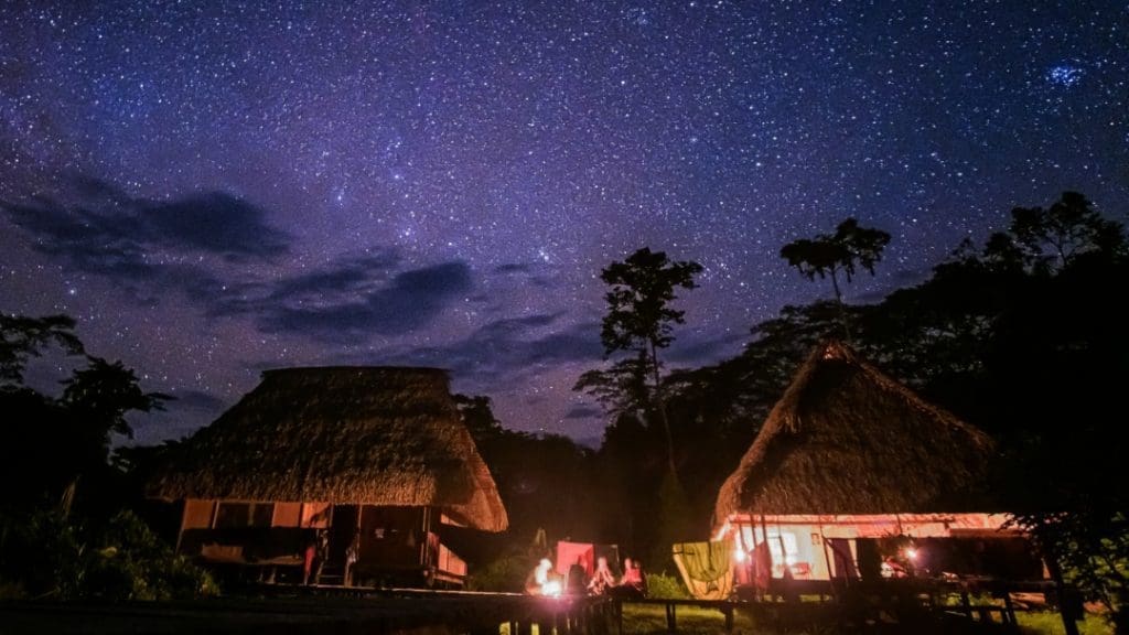 The cabins at the Kichwa Lodge stand under the night sky filled with an innumerable amount of stars